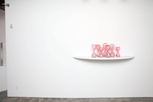Installation art view at Garis & Hahn Gallery in New York City of glass pink hourglasses by Zoe Buckman.