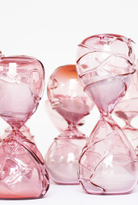 Close–up image of pink hand blown glass sculptures of hourglasses to represent the temporary nature of life.