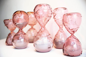 Pink hand blown glass sculptures of hourglasses to represent the temporary nature of life.